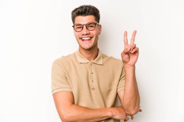 Beyaz arka planda izole edilmiş genç beyaz adam iki numarayı parmaklarıyla gösteriyor..