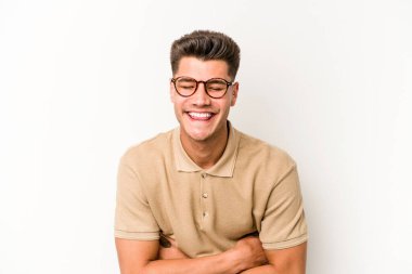 Beyaz arka planda izole genç beyaz adam gülüyor ve eğleniyor..
