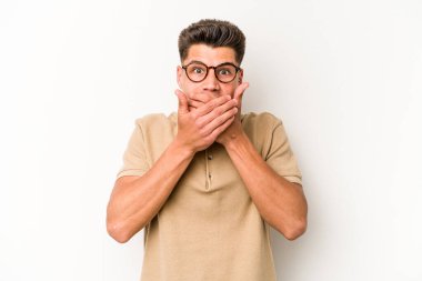 Beyaz arka planda izole edilmiş genç beyaz bir adam ağzı kapalı ve elleri endişeli görünüyor..