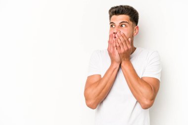 Beyaz arka planda izole edilmiş beyaz tenli genç adam ağzını eliyle kapatan bir fotokopi odasına bakıyor..