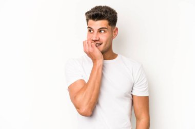 Beyaz arka planda izole edilmiş, tırnak yiyen, gergin ve endişeli genç bir beyaz adam..