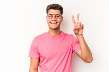 Beyaz arka planda izole edilmiş genç beyaz adam iki numarayı parmaklarıyla gösteriyor..