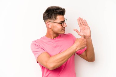 Beyaz arka planda izole edilmiş genç beyaz bir adam gülümseyerek beş numarayı parmaklarıyla gösteriyor..