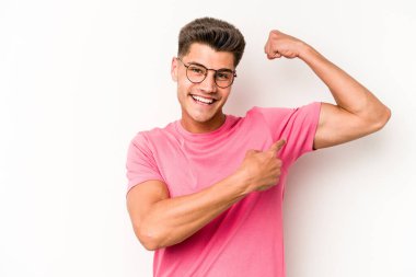 Beyaz arka planda izole edilmiş genç beyaz bir adam güçlü bir hareket gösteriyor, kollarıyla, kadınsı gücün sembolü.