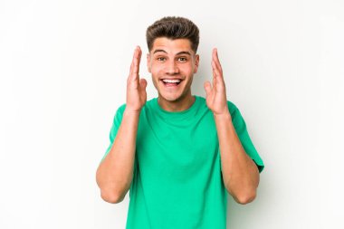 Beyaz arka planda izole genç beyaz adam yüksek sesle gülüyor elini göğsüne koyuyor..