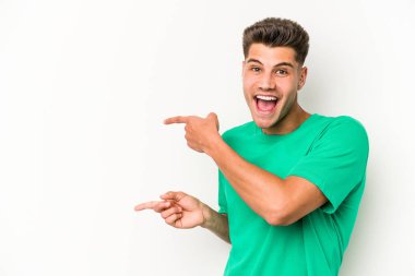 Beyaz arka planda izole edilmiş genç beyaz bir adam işaret parmağıyla işaret ettiği için heyecanlı..