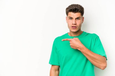 Beyaz arka planda izole edilmiş genç beyaz adam yan tarafı işaret ediyor