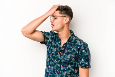 Beyaz arka planda izole edilmiş genç beyaz bir adam bir şeyi unutuyor. Alnına avuç içi ve gözlerini kapayarak vuruyor..