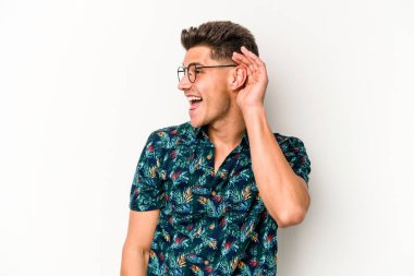 Beyaz arka planda izole edilmiş genç beyaz adam bir dedikoduyu dinlemeye çalışıyor..