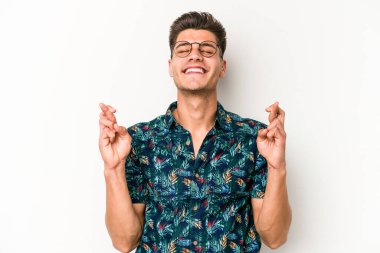 Beyaz arka planda izole genç beyaz adam şans dilemek için şans diliyor.