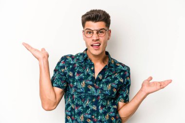 Beyaz arka planda izole edilmiş genç beyaz bir adam. Kafası karışmış ve omuz silkiyor. Kopya alanını tutmak için..