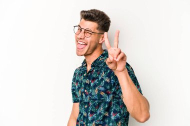 Beyaz arka planda izole edilmiş genç beyaz adam iki numarayı parmaklarıyla gösteriyor..