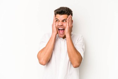 Beyaz arka planda izole edilmiş genç beyaz bir adam kulakları kulaklarıyla kapatıyor ve çok ses duymamaya çalışıyor..