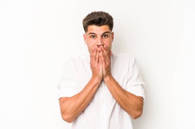 Beyaz arka planda izole edilmiş genç beyaz bir adam ağzı kapalı ve elleri endişeli görünüyor..