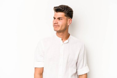 Beyaz arka planda izole edilmiş genç beyaz bir adam omuz silkiyor ve gözleri açık..