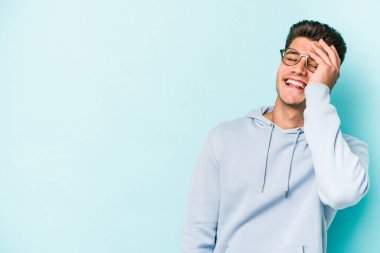 Kafkasyalı genç adam mavi arka planda yalnızdı gülerek, kaygısızca, doğal duygularla.