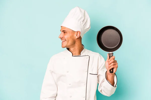 年轻的高加索厨师拿着蓝色背景的飞盘 面带微笑 开开开心心 令人愉快 — 图库照片