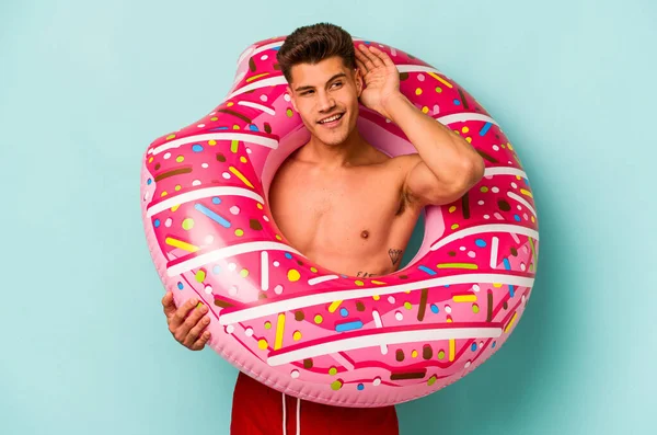 Young Caucasian Man Holding Inflatable Donut Isolated Blue Background Trying —  Fotos de Stock
