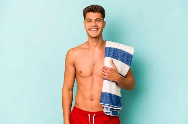 Young Caucasian Man Holding Beach Towel Isolated Blue Background Happy — Stockfoto