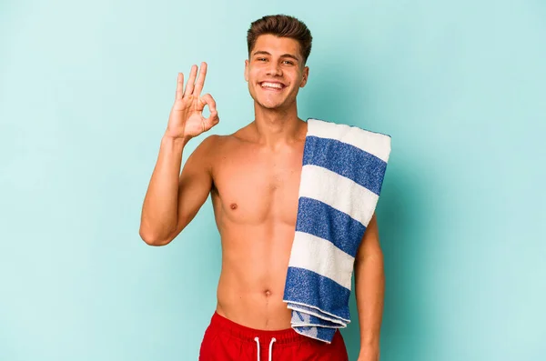 Young Caucasian Man Holding Beach Towel Isolated Blue Background Cheerful — Stock fotografie
