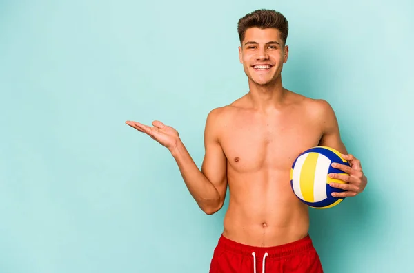 Young Caucasian Man Playing Volley Isolated Blue Background Showing Copy — Stok fotoğraf