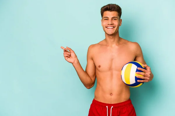 Young Caucasian Man Playing Volley Isolated Blue Background Smiling Pointing — Stok fotoğraf
