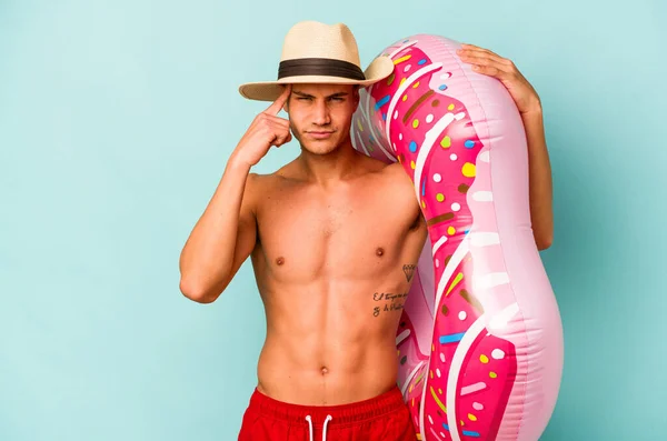 Young Caucasian Man Holding Inflatable Donut Isolated Blue Background Pointing — Stock fotografie