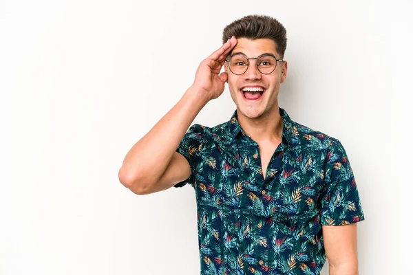 Beyaz arka planda izole genç beyaz adam yüksek sesle bağırıyor, gözleri açık ve elleri gergin tutuyor..