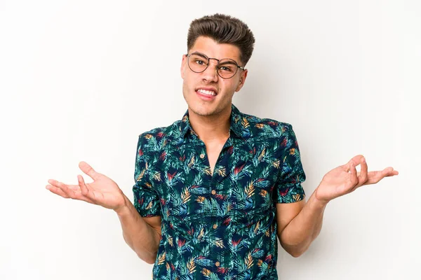 Beyaz arka planda izole edilmiş genç beyaz bir adam sorgulama sırasında omuz silkiyor ve şüphe duyuyor..