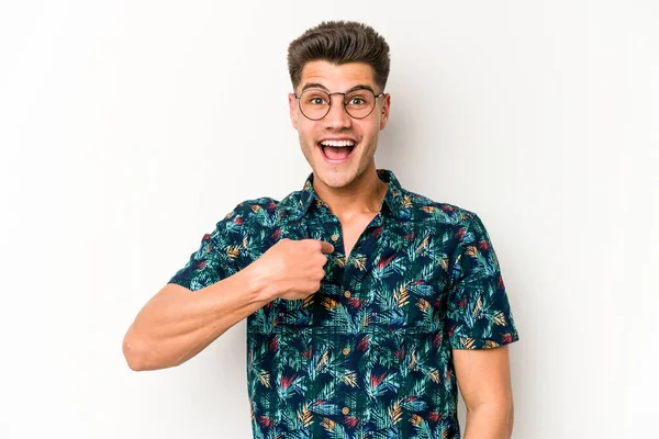 Beyaz arka planda izole edilmiş genç beyaz bir adam parmağını göstererek şaşırdı, geniş bir gülümsemeyle..