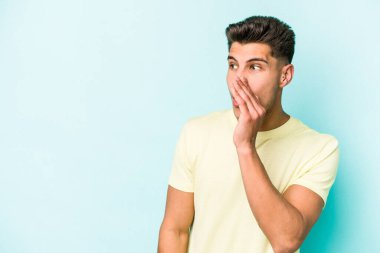 Kafkasyalı genç adam mavi arka planda izole edilmişti. Gördüğü bir şey yüzünden şok olmuştu..