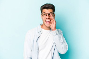 Mavi arka planda izole edilmiş beyaz bir adam heyecanlı bir şekilde bağırıyor..