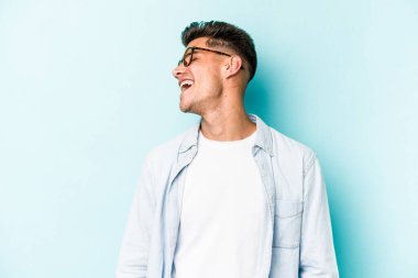 Genç beyaz adam mavi arka planda izole edilmiş dans ediyor ve eğleniyor..