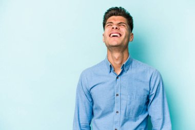 Kafkasyalı genç adam mavi arka planda izole edilmiş. Çok kızgın, öfkeli, hayal kırıklığına uğramış..