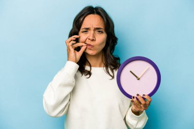 Mavi arka planda saati tutan genç İspanyol kadın parmakları dudaklarında bir sır saklıyor..