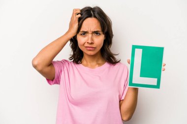 Genç İspanyol kadın elinde acemi sürücü tabelası tutuyordu. Beyaz arka planda izole edilmişti. Şok oluyordu..