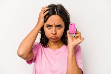 Beyaz arka planda izole edilmiş araba anahtarlarını tutan genç İspanyol kadın şokta, önemli bir toplantıyı hatırladı..