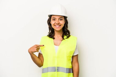 Latin kökenli genç bir kadın, beyaz arka planda izole edilmiş. Elle bir tişört fotokopi alanını işaret ediyor.