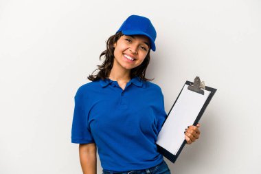 Beyaz arka planda izole edilmiş genç İspanyol kadın teslimatçısı mutlu, güler yüzlü ve neşeli..