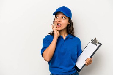 Beyaz arka planda izole edilmiş genç İspanyol kadın teslimatçı gizli bir sıcak fren haberi veriyor ve yana bakıyor.