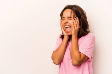 Young hispanic woman isolated on white background shouts loud, keeps eyes opened and hands tense.