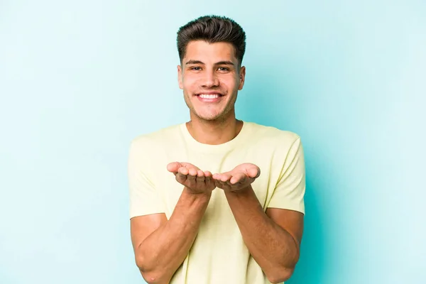 Joven Hombre Caucásico Aislado Sobre Fondo Azul Sosteniendo Algo Con — Foto de Stock