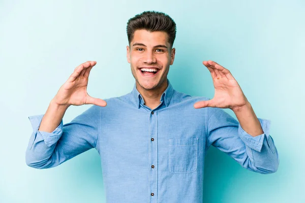 Jonge Blanke Man Geïsoleerd Blauwe Achtergrond Met Iets Met Handpalmen — Stockfoto