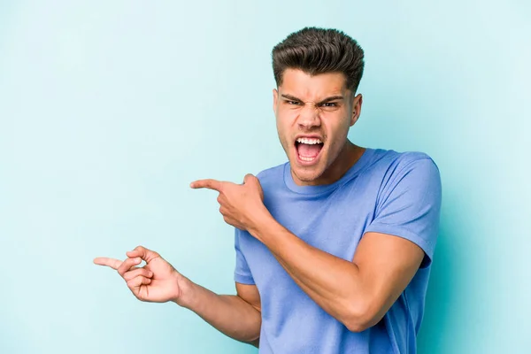Young Caucasian Man Isolated Blue Background Pointing Forefingers Copy Space — Stock Photo, Image