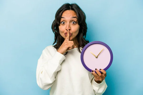 Young Hispanic Woman Holding Clock Isolated Blue Background Keeping Secret — Stok fotoğraf