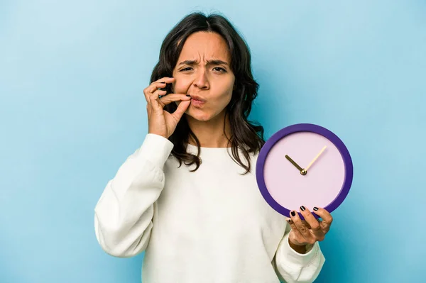 Young Hispanic Woman Holding Clock Isolated Blue Background Fingers Lips — Stok fotoğraf