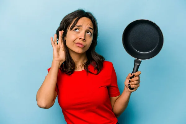 Junge Hispanische Frau Hält Eine Bratpfanne Isoliert Auf Blauem Hintergrund — Stockfoto