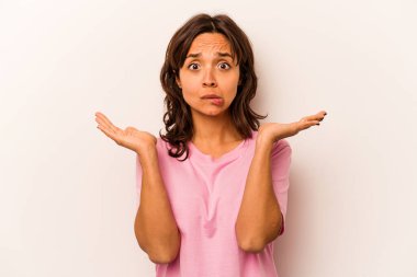 Beyaz arka planda izole edilmiş genç İspanyol bir kadın. Kafası karışmış ve omuz silkiyor. Kopya alanını tutmak için..