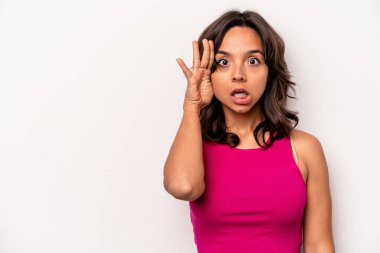 Beyaz arka planda izole edilmiş genç İspanyol kadın yüksek sesle bağırıyor, gözleri açık ve elleri gergin tutuyor..