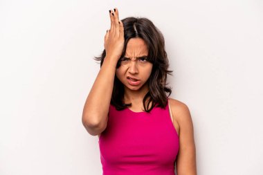 Beyaz arka planda izole edilmiş genç İspanyol kadın bir şeyi unutuyor. Alnına avuç içiyle vurup gözlerini kapatıyor..
